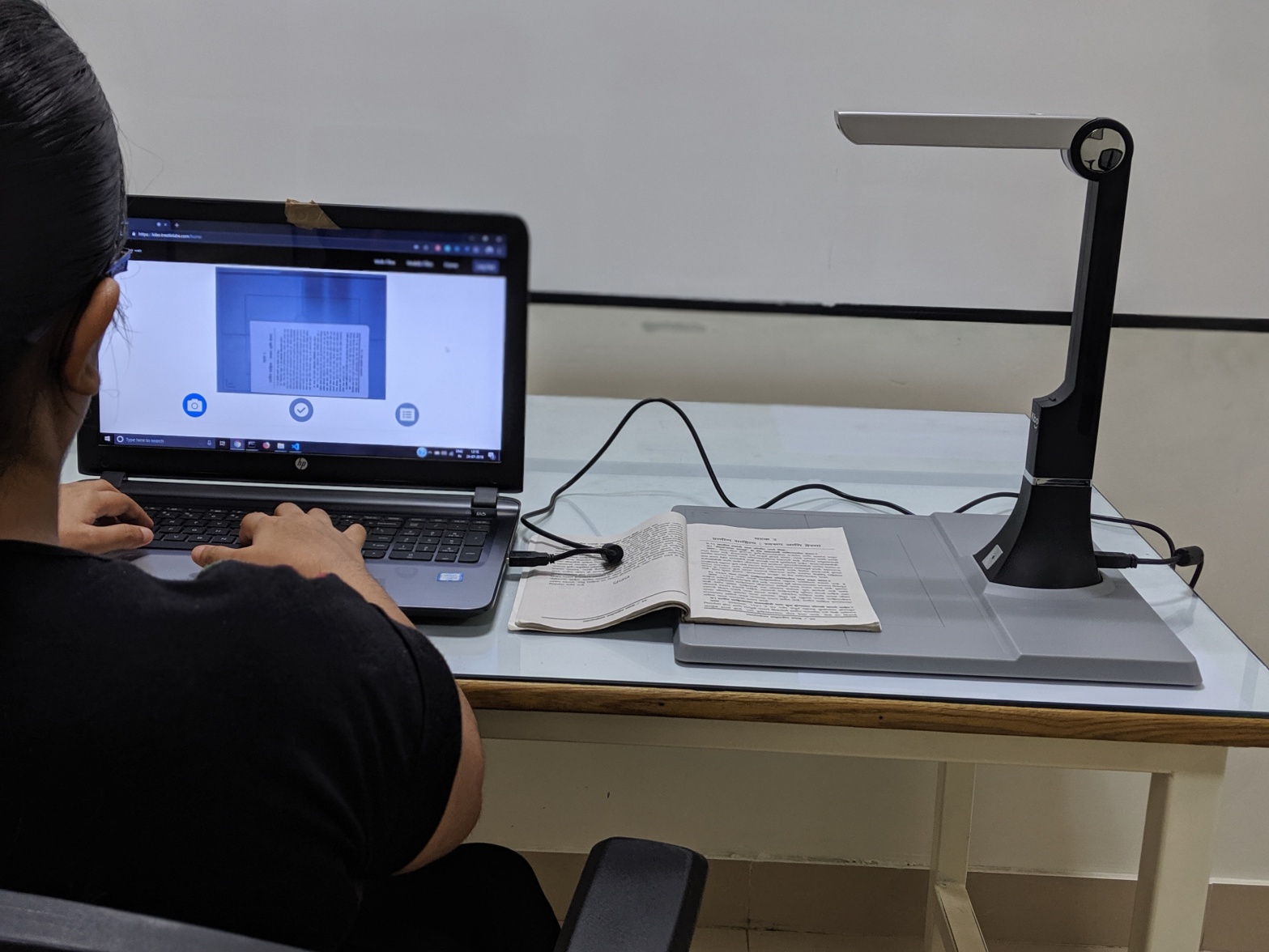 A person scanning book on a system through KIBO XS device.
